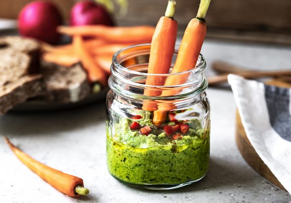 Spinach Hummus in a glass jar by baby Carrot and Rye bread