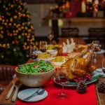 Diner decoration gift box in background on festive christmas tree and cheerful prepare roasted turkey and red wine drink and full set of food fruit and desert sweet for thanksgiving